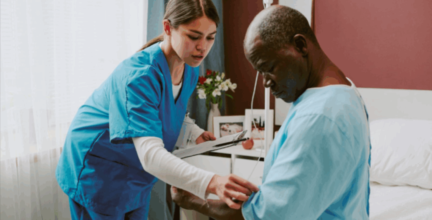 A nurse checks on an elderly male patient seated on a hospital bed during routine rounds.