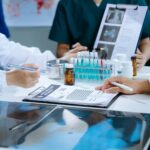 A team of clinical research nurses work in a lab with vials and notes.