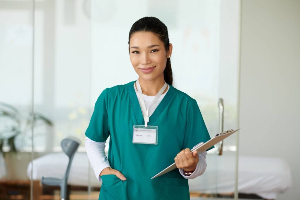 A nurse smiles while carrying a clipboard and making her rounds.