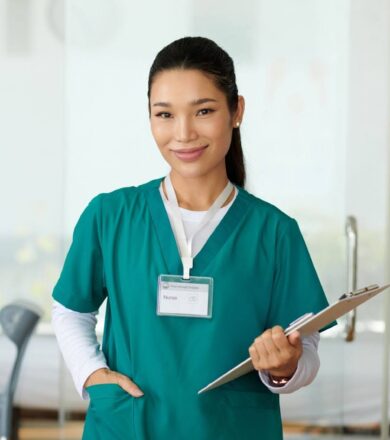 A nurse smiles while carrying a clipboard and making her rounds.