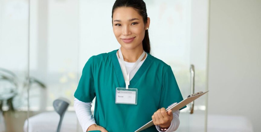 A nurse smiles while carrying a clipboard and making her rounds.