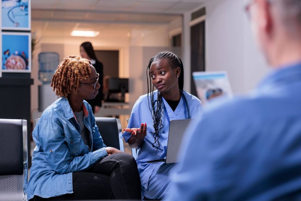 Nurse speaking to a patient in a waiting room.