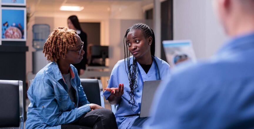 Nurse speaking to a patient in a waiting room.
