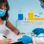Nursing holding out a form for a patient to sign. 