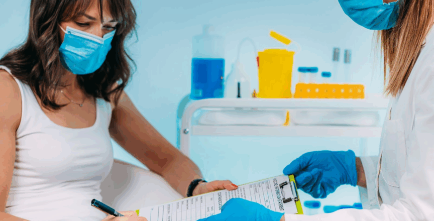 Nursing holding out a form for a patient to sign. 